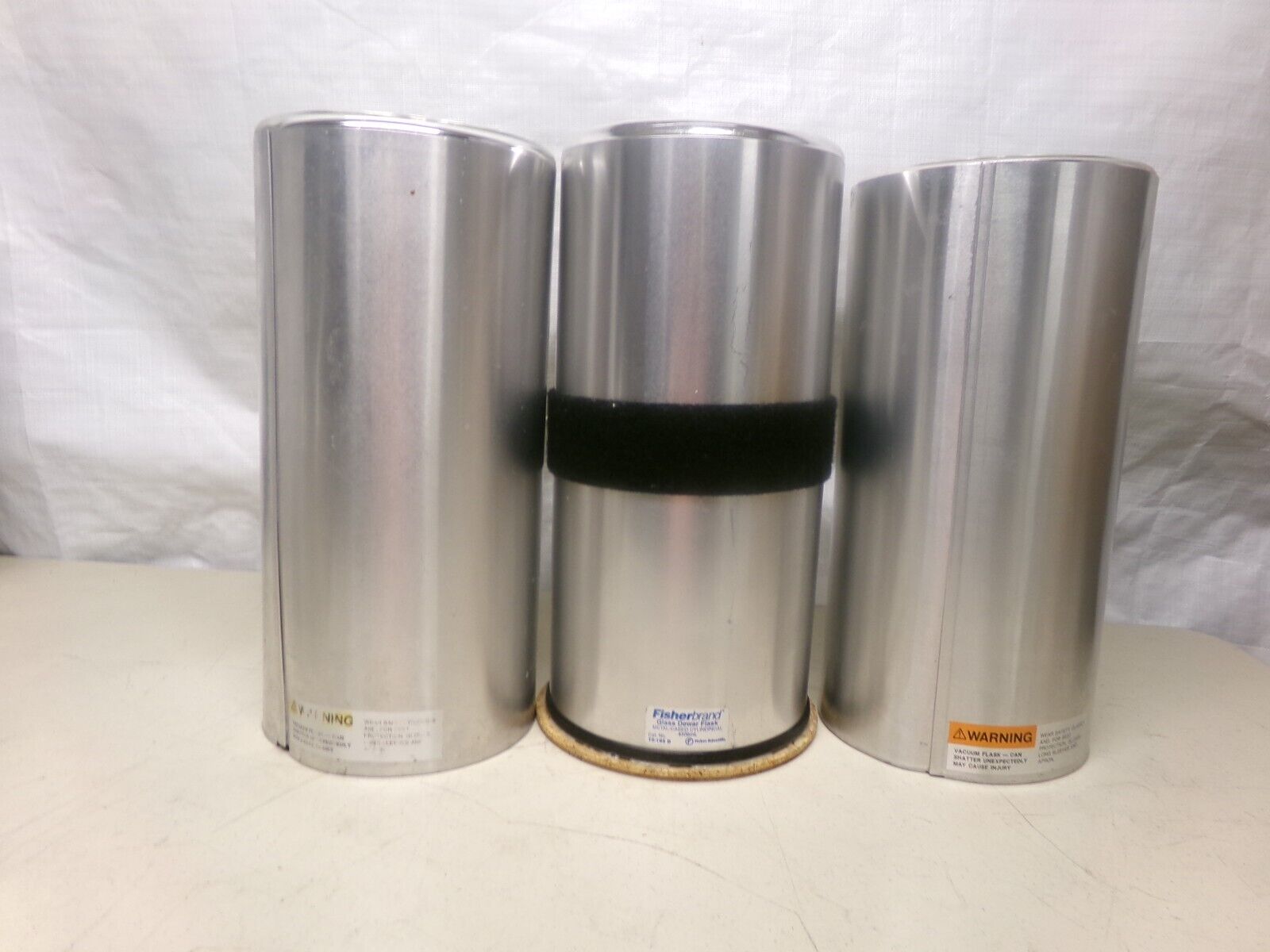 Three silver metal cylinders on a table.