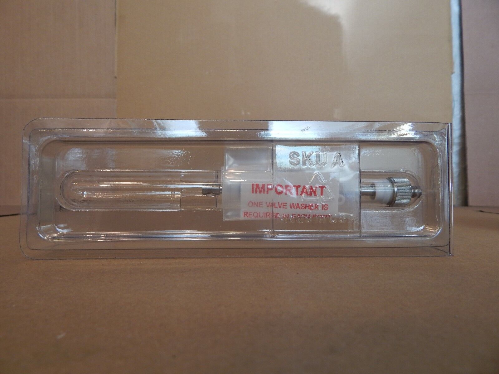 A clear plastic package containing a small glass tube.