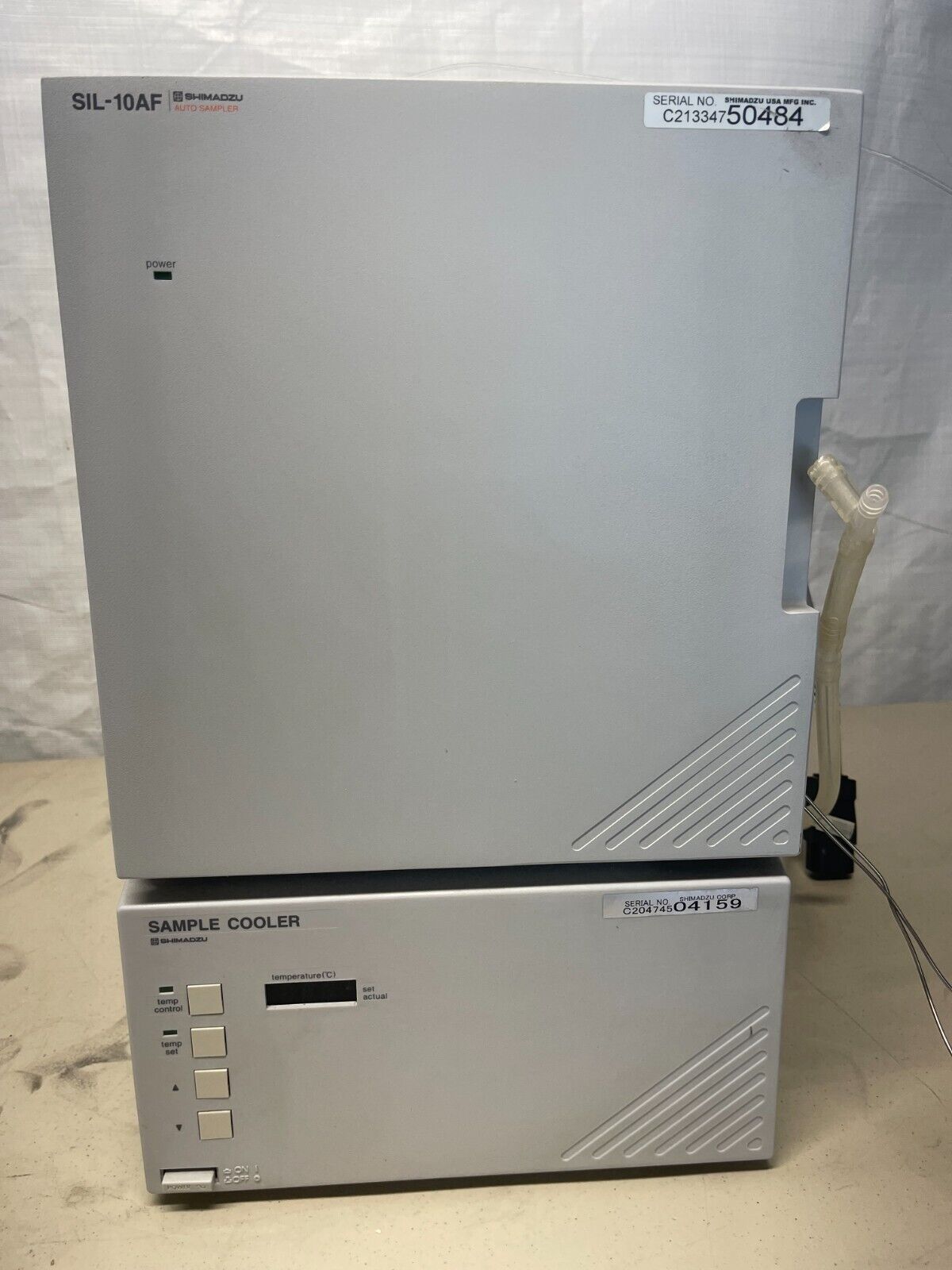 A gray sample cooler with a black power cord.