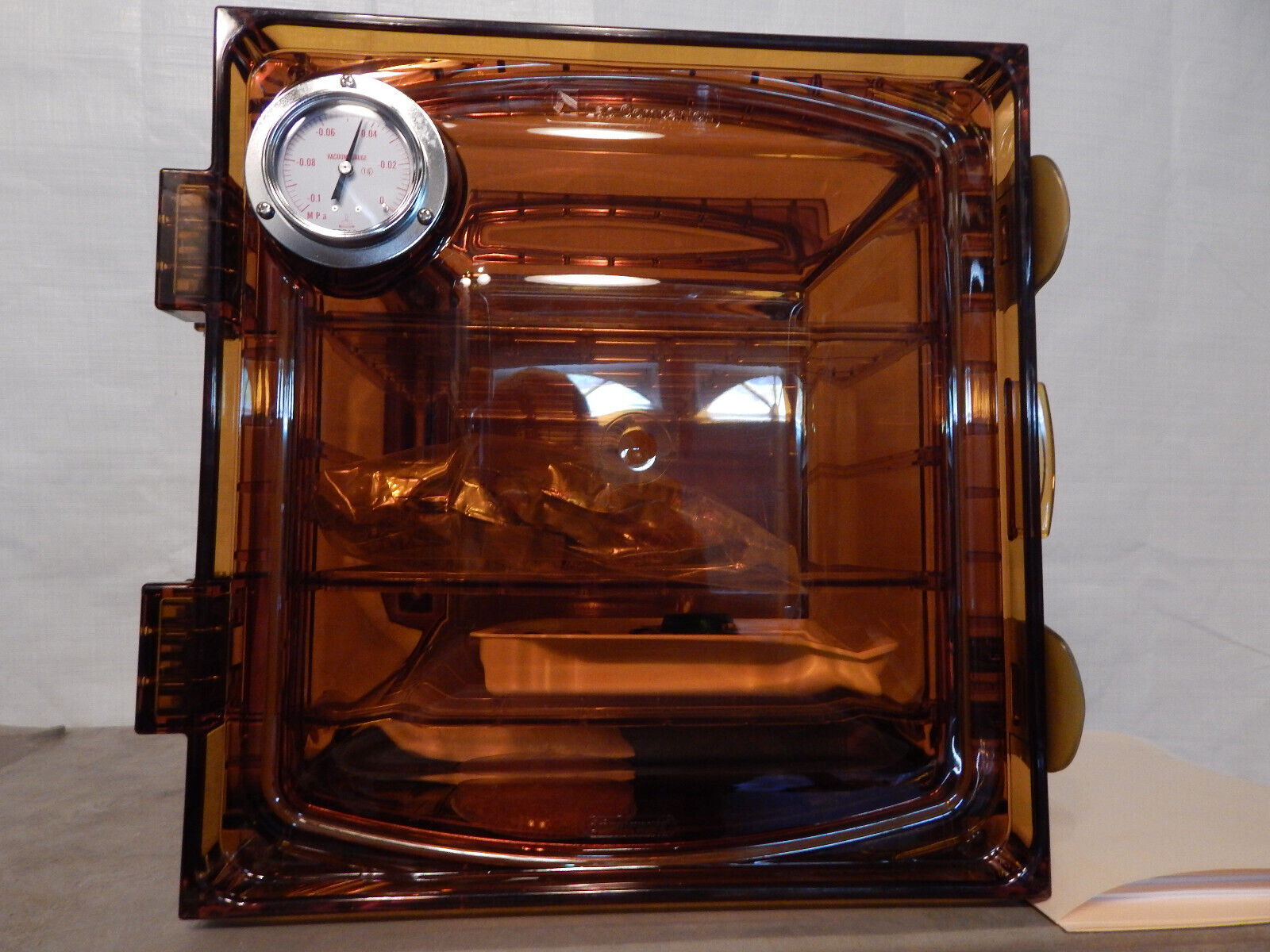 Vacuum chamber with a gauge and two knobs.